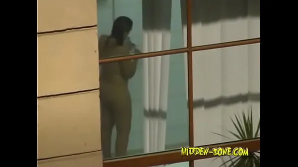 بڑے A girl washes in the shower, and we see her through the window ٹاپ کلپس